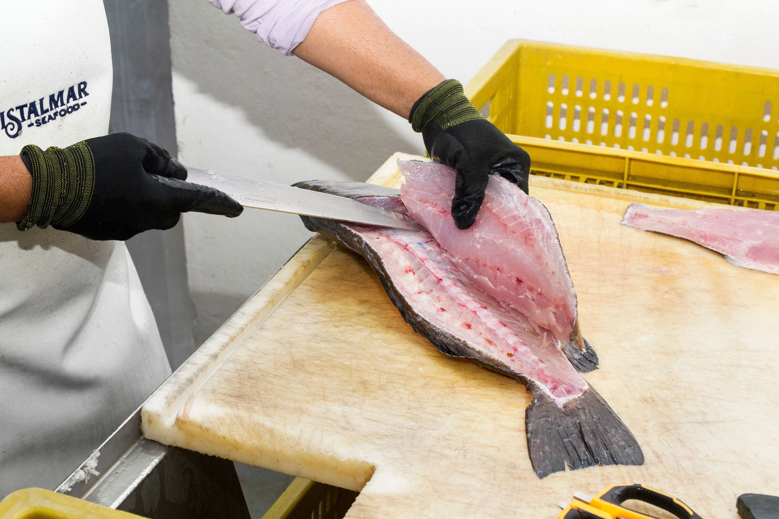 Fish being filleted at a production partner facility